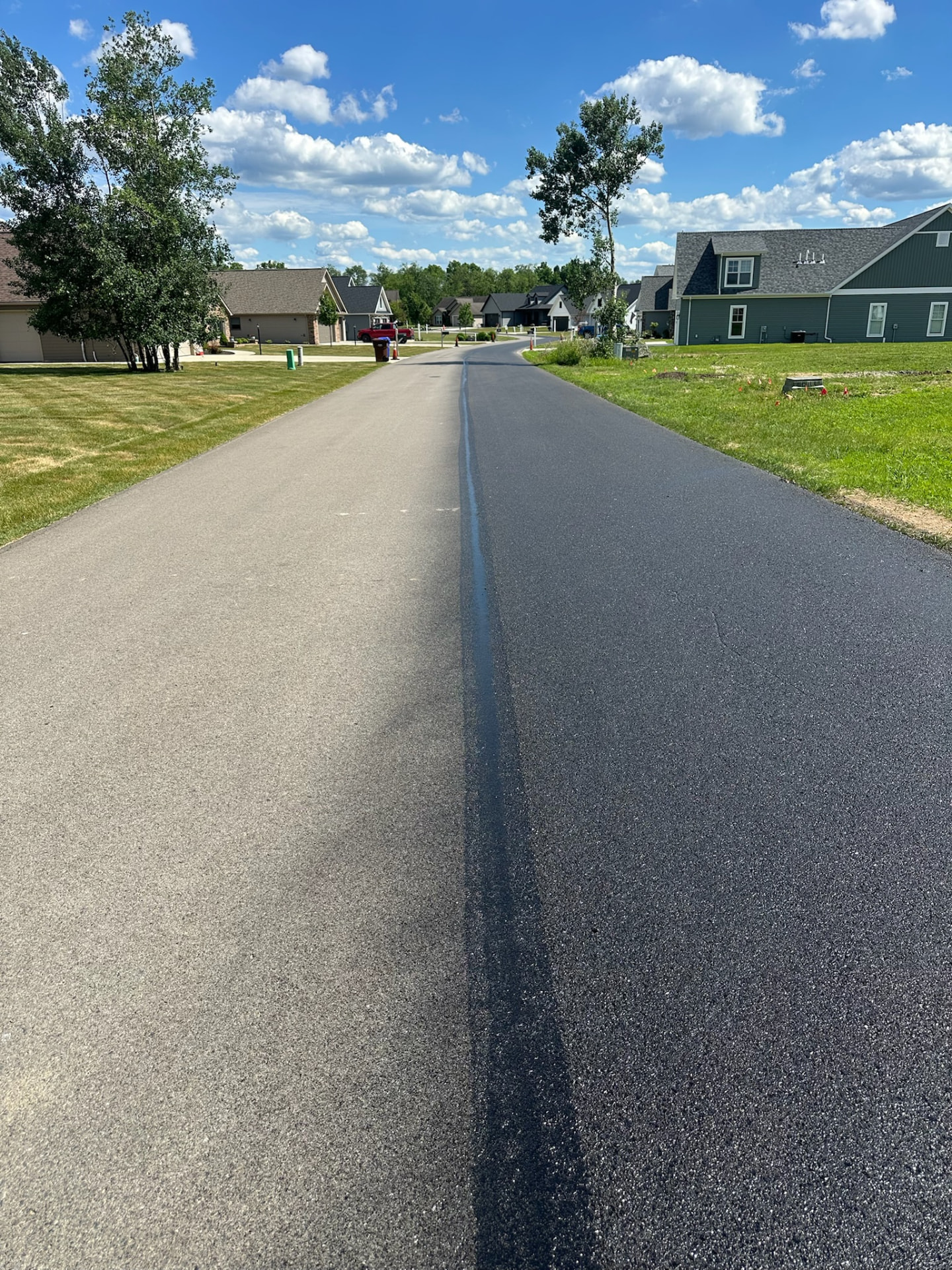 RevivaRoad product application photograph — asphalt preservation treatment being applied to existing pavement